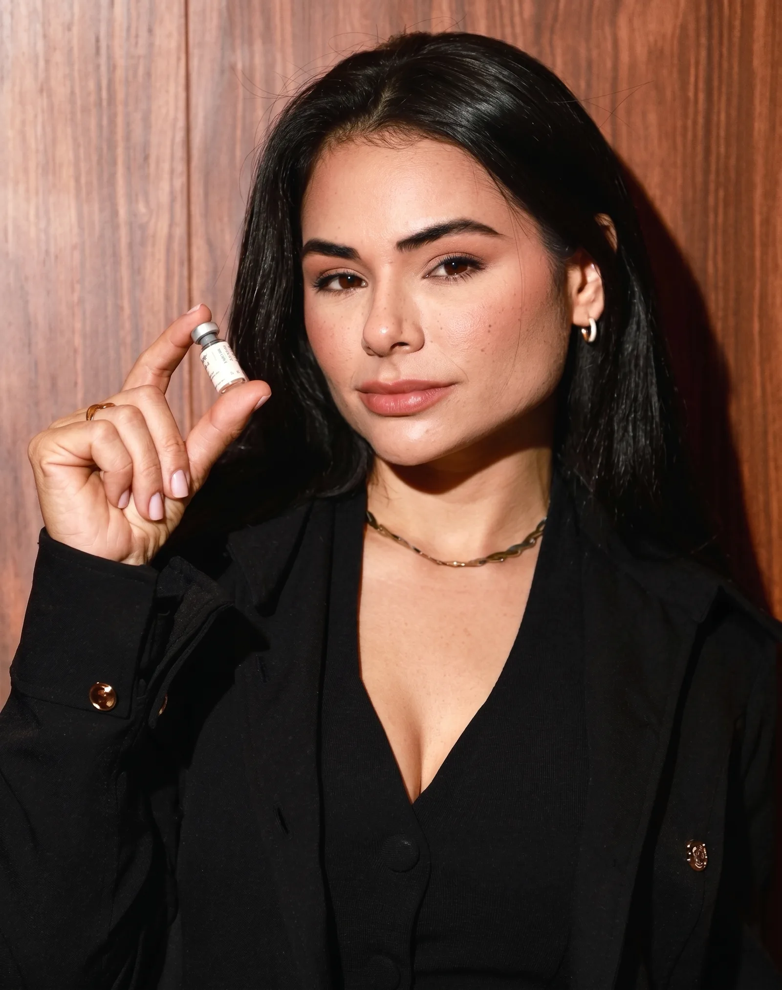 Dra. Priscila Sousa, biomédica esteta, segurando frasco de terapia injetável em consultório de estética avançada em Santos